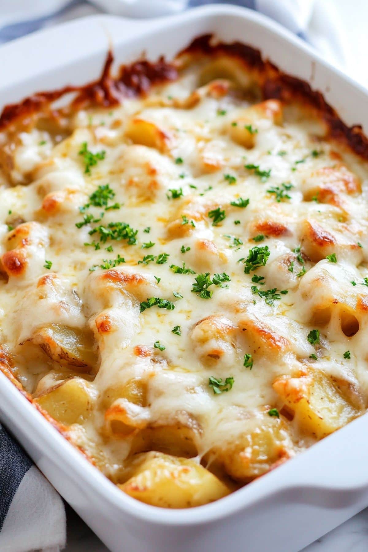 Baked potatoes with cheesy french soup in a baking dish.