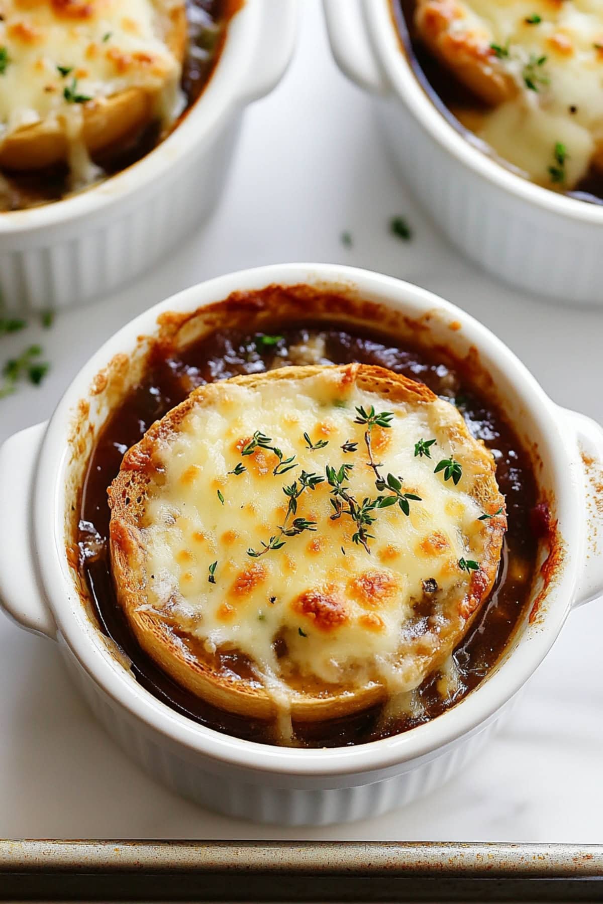 French onion soup in topped with cheesy slice of baguette, top view