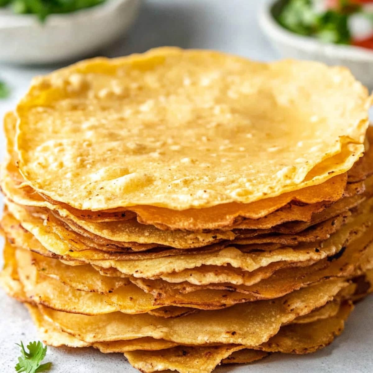 Stack of crispy corn tortillas on a table.