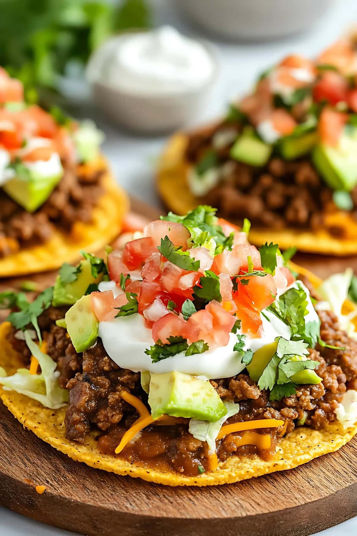 Tostadas with ground beef, beans, tomatoes and sour cream, close up