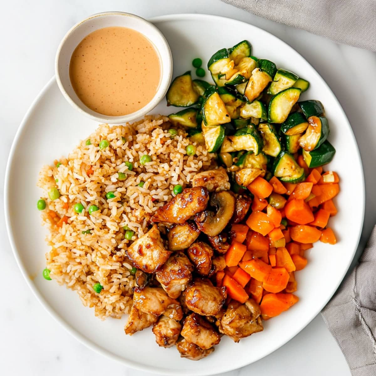 Hibachi chicken served with yum yum sauce, vegetables, and fried rice.