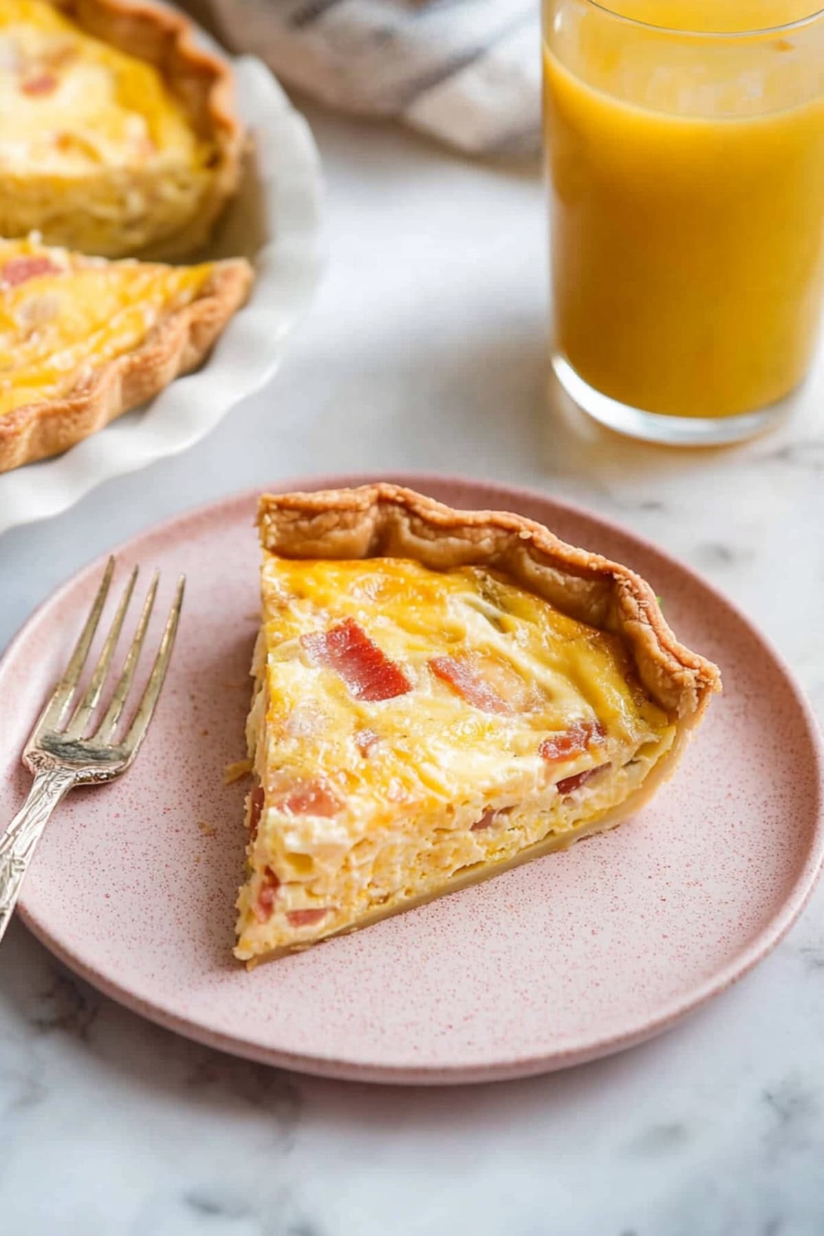 Homemade bacon and cheese quiche, served with a glass of mango juice on the side