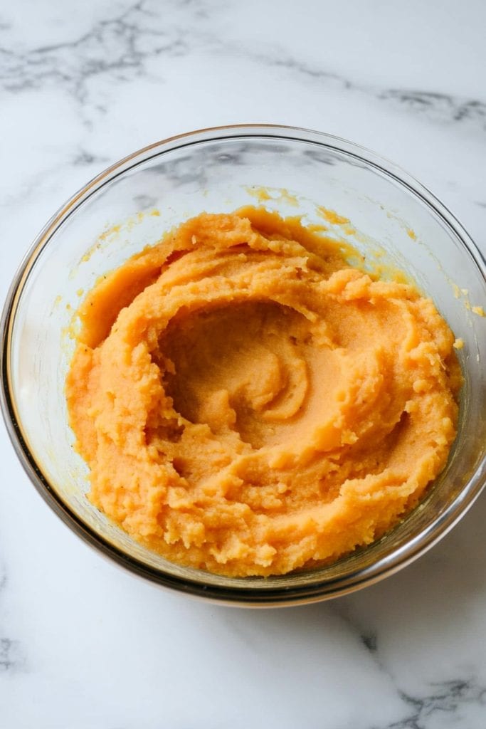 A glass bowl of sweet mashed potatoes.