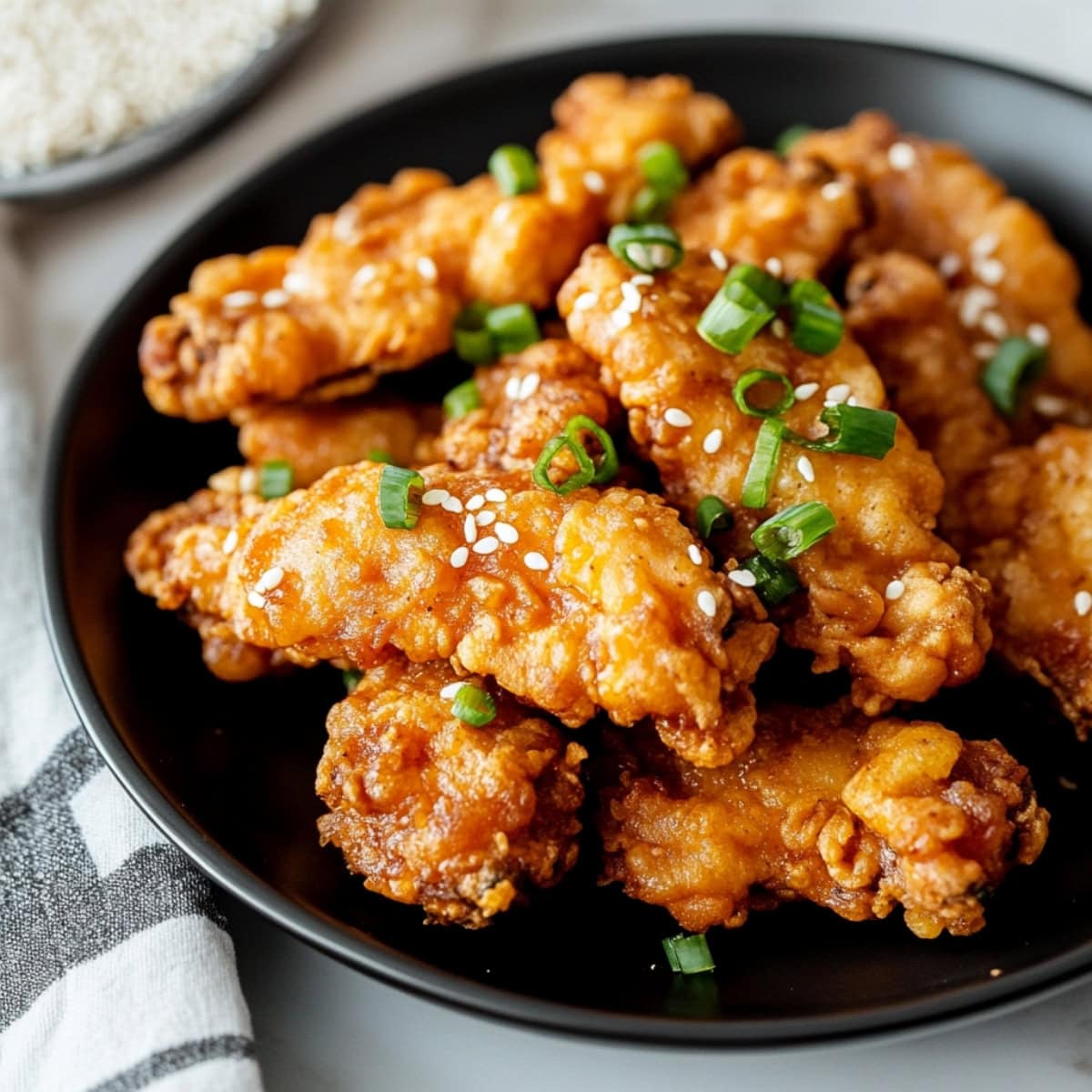 Crispy mochiko chicken pieces in a black plate.