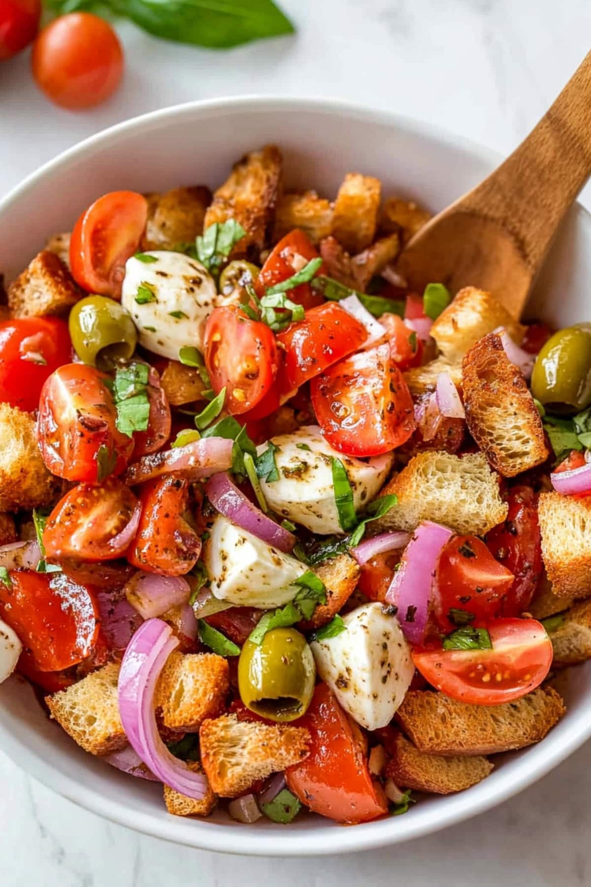 Colorful Panzanella salad with fresh tomatoes, red onions, and crispy croutons, tossed in olive oil and balsamic vinegar.