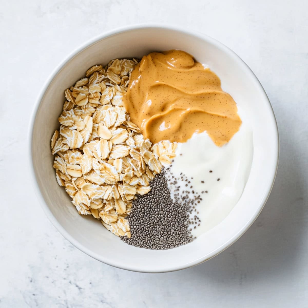 Peanut Butter, Oats, Chia Seeds and Yogurt in a Bowl, top view.