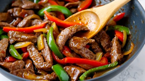 Pepper steak fry served in a skillet, with strips of beef and red, and green peppers tossed in a soy-garlic glaze.