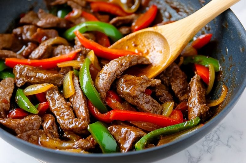 Pepper steak fry served in a skillet, with strips of beef and red, and green peppers tossed in a soy-garlic glaze.