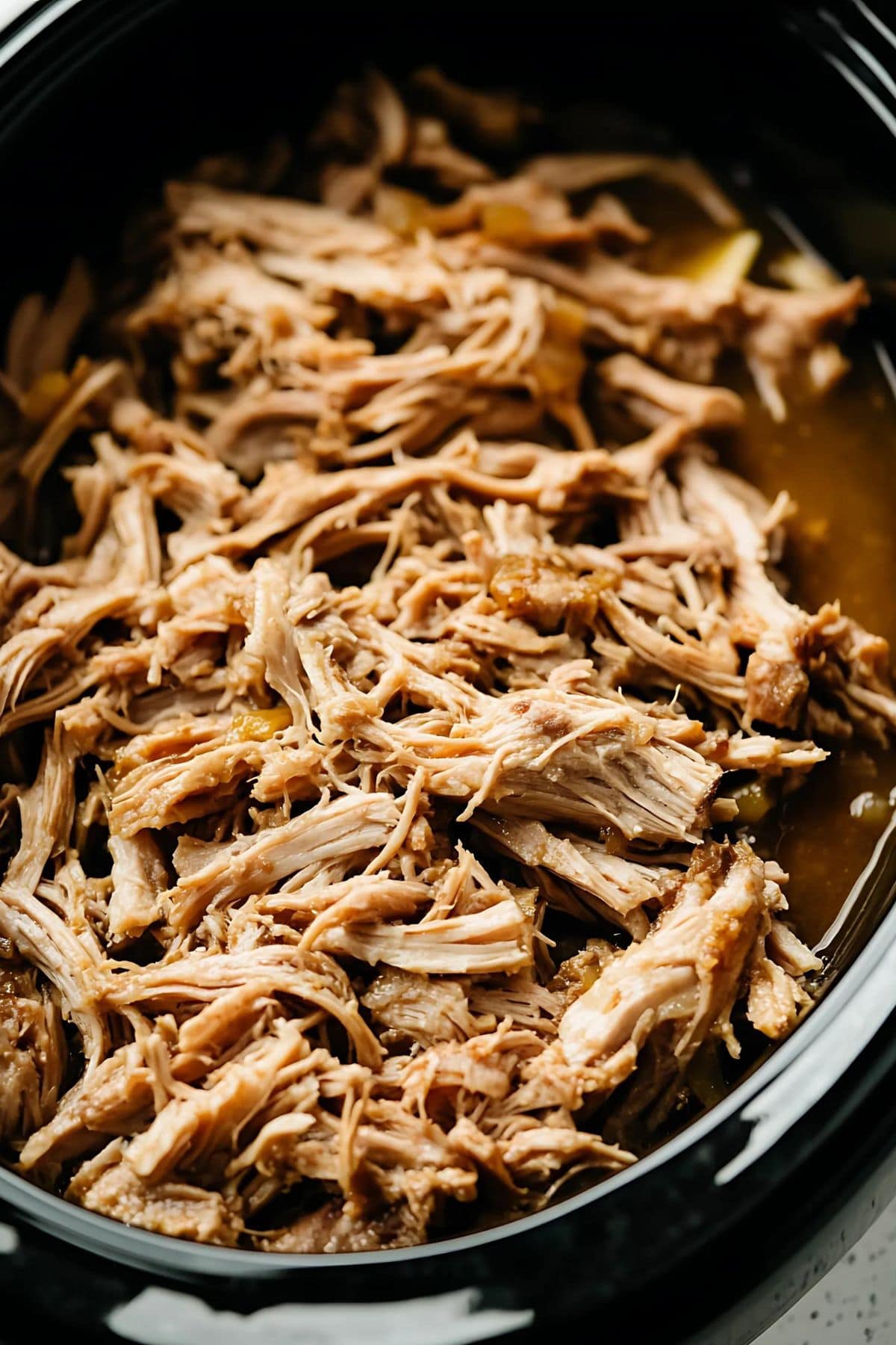 Pulled pork cooked inside a slow cooker.