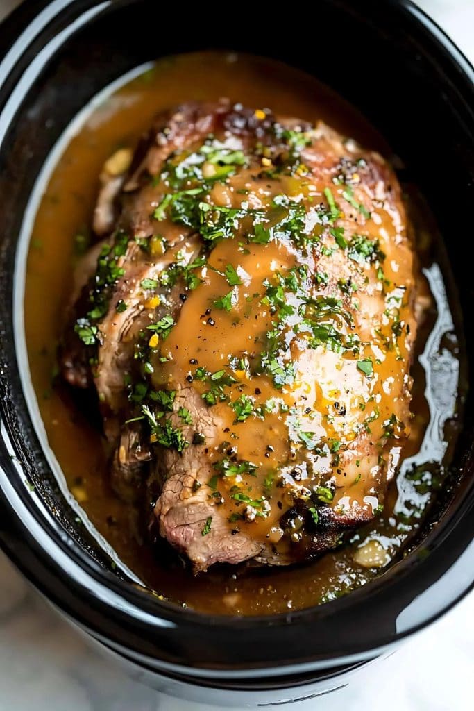 Marinated pork butt roast in a slow cooker.