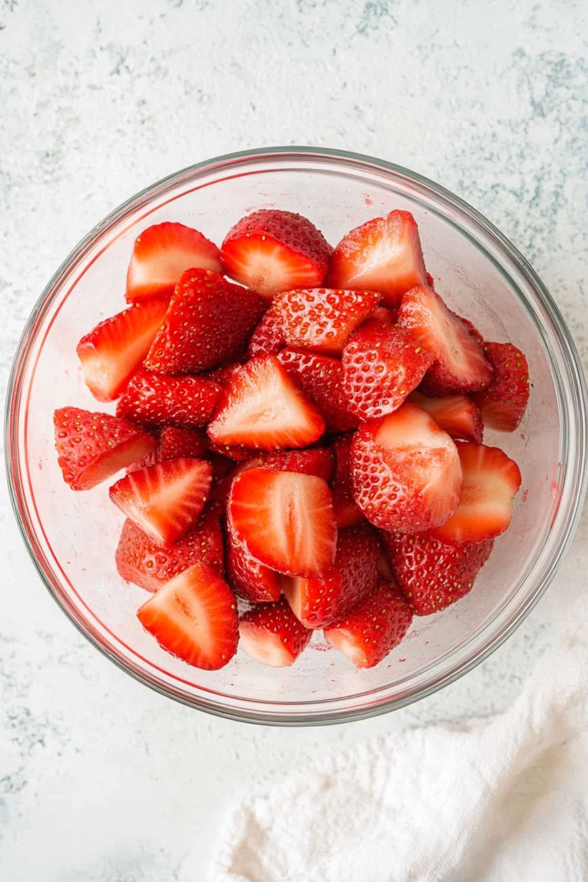 Sliced fresh strawberries in a glass bowl.