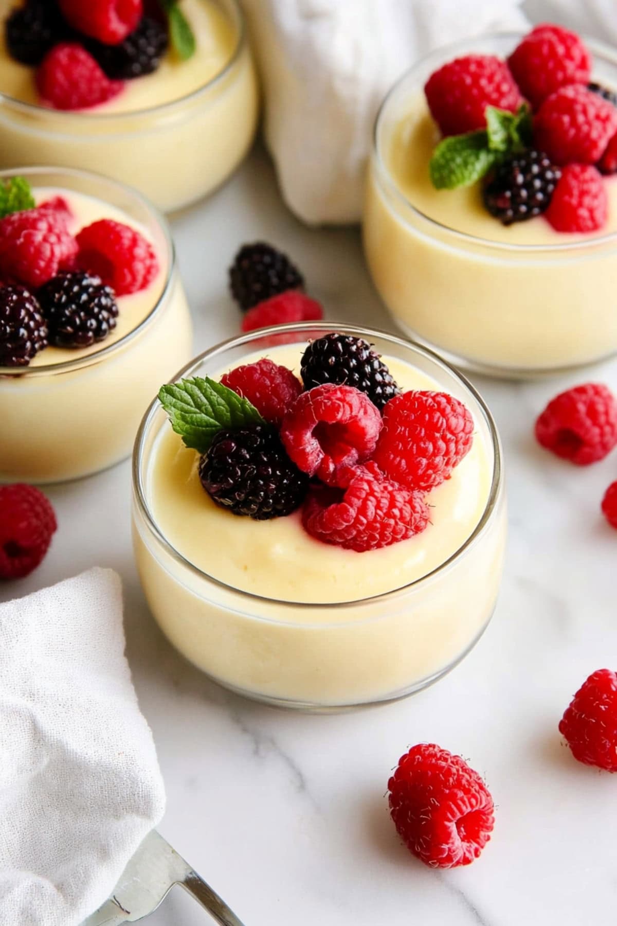 Homemade vanilla pudding with fresh berries on top.