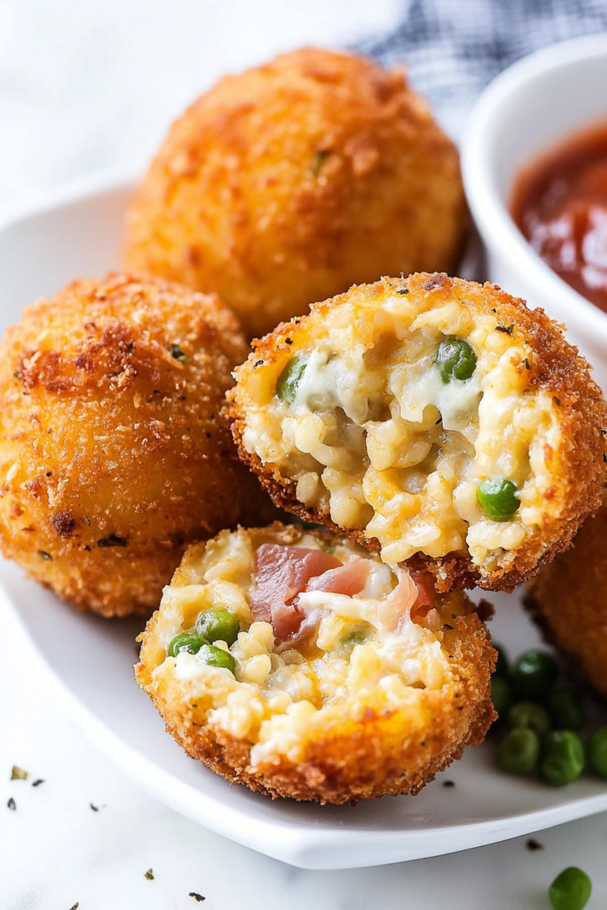 Cheesy and golden homemade arancini with ketchup on the side.