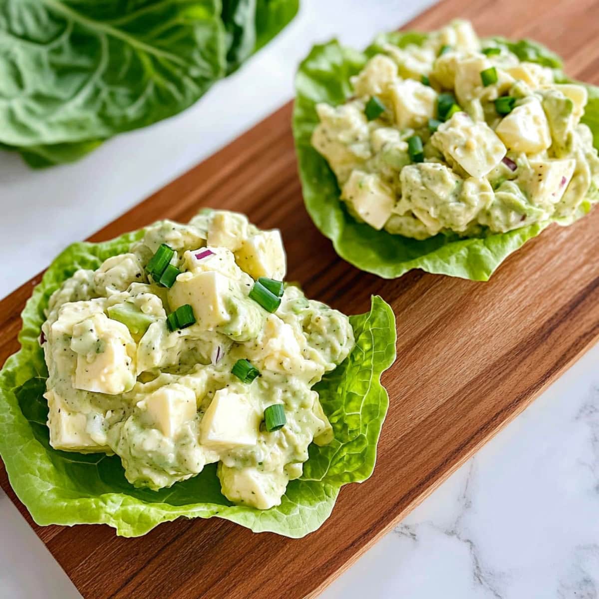 Avocado salad served on top of lettuce leaves.