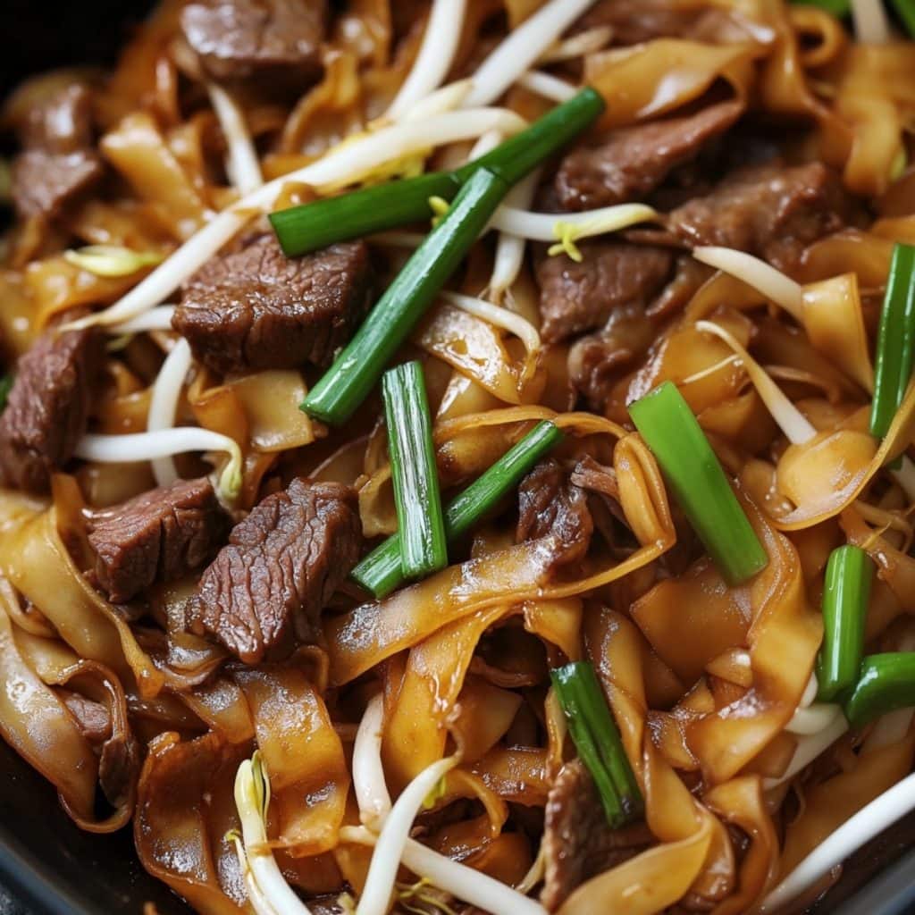 Closeup shot of beef chow fun in a skillet pan.