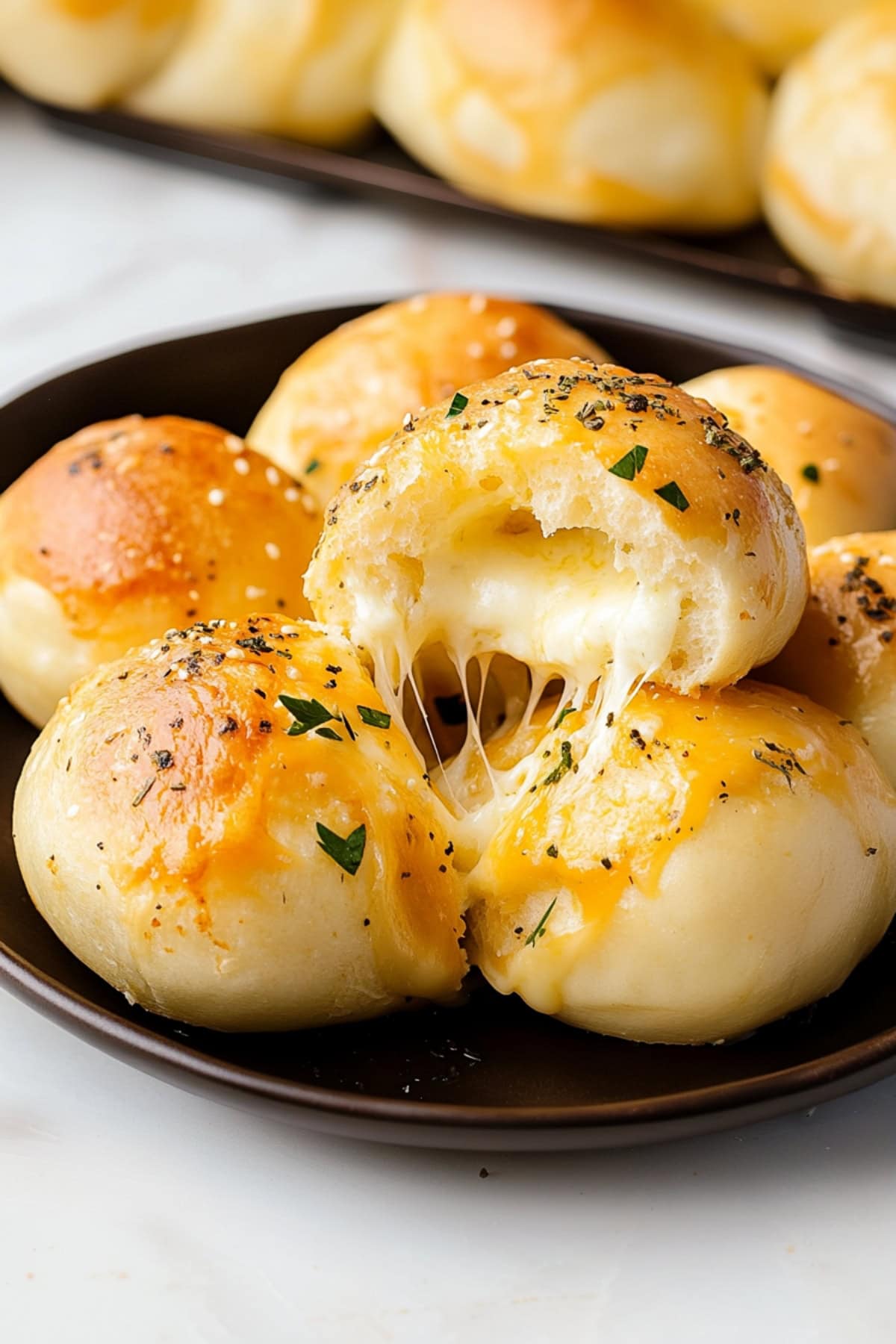 A close-up shot of cheese bombs with perfectly baked dough, revealing a melty cheese core inside.