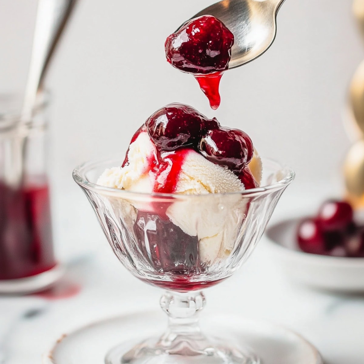 Vanilla ice cream topped with Cherries Jubilee in a glass serving bowl