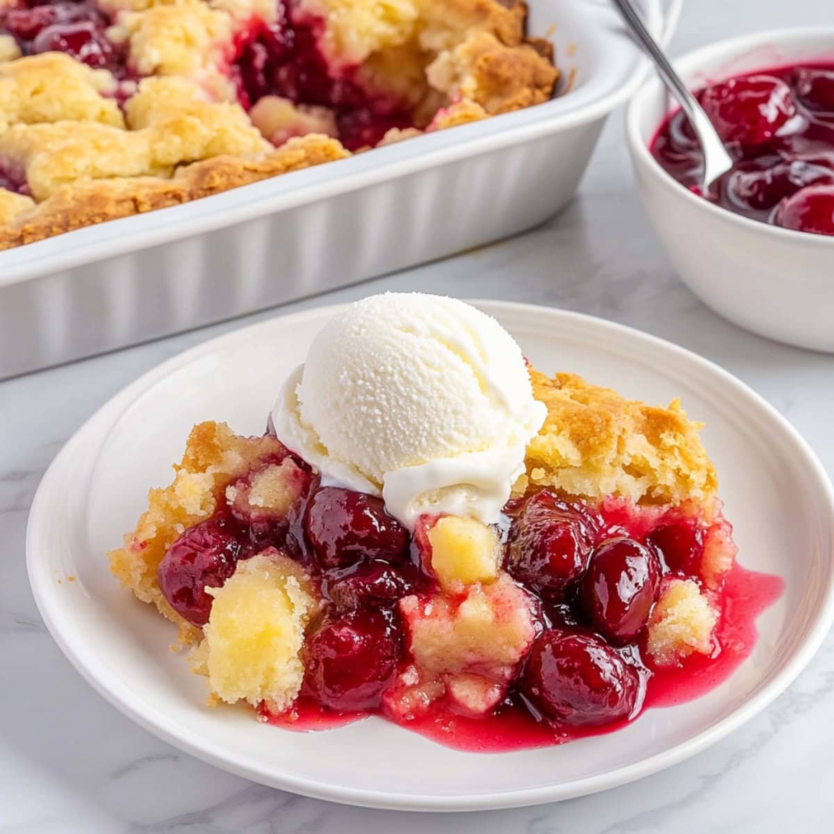 Cherry Pineapple Dump Cake on a plate with ice cream