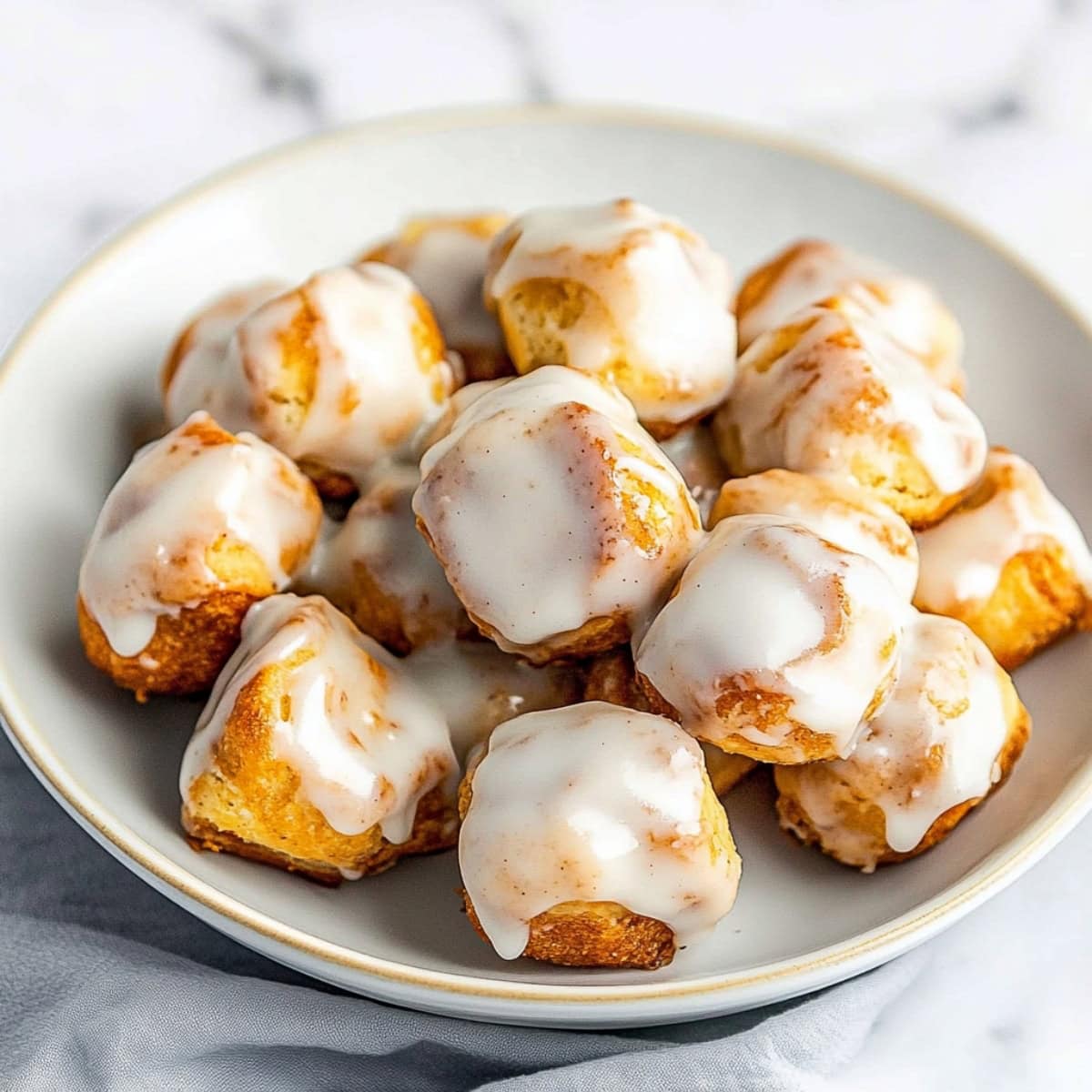 Cinnamon Roll chunks drizzled in sweet glaze in a bowl