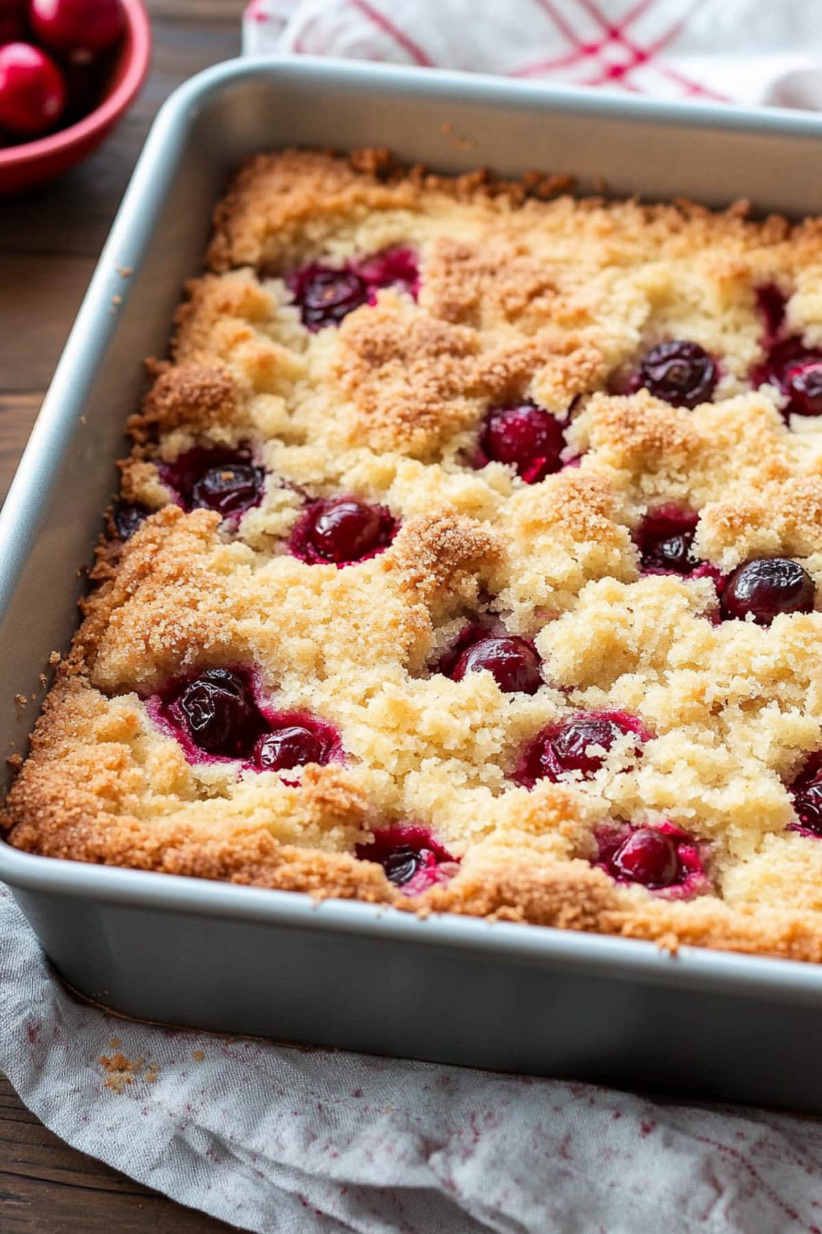 Coffee cake in a baking dish with cranberries.