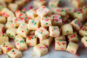 Bunch of square slices of shortbread bites scattered on a marble table.