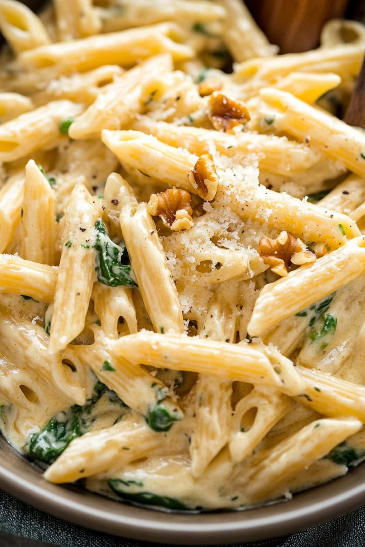 Creamy homemade gorgonzola pasta with spinach and walnuts, close-up