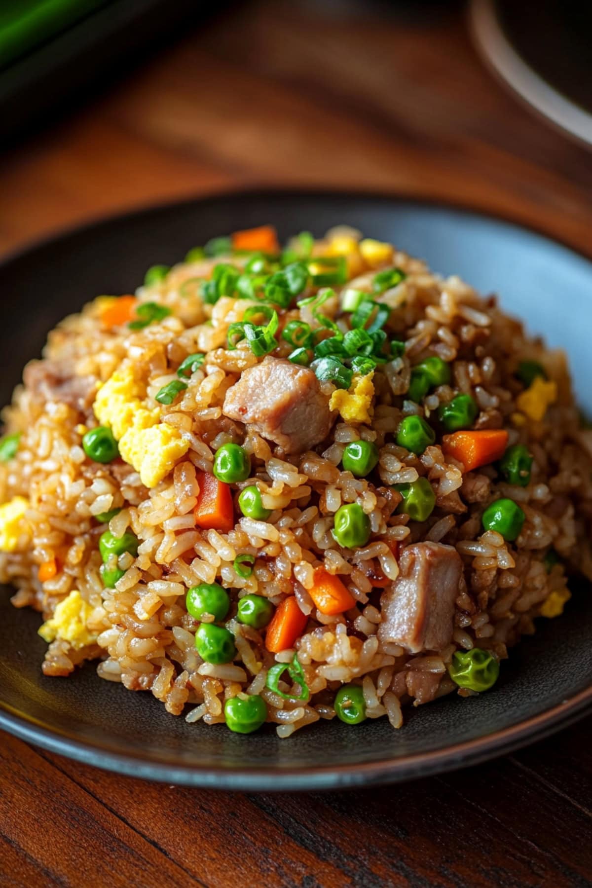 Quick and easy pork fried rice with scrambled eggs and veggies.