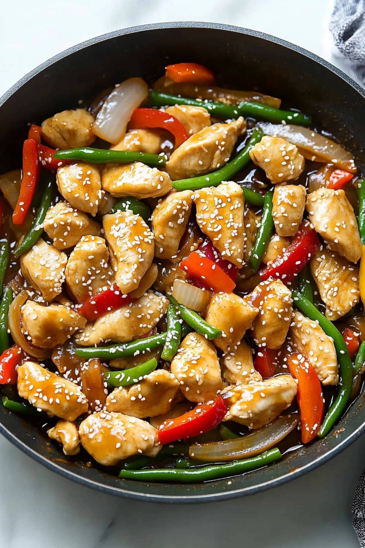 Lemon chicken stir-fry with veggies in a skillet.