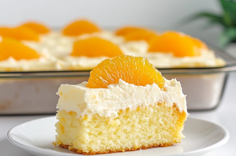 Slice of cake with white frosting and orange on top.