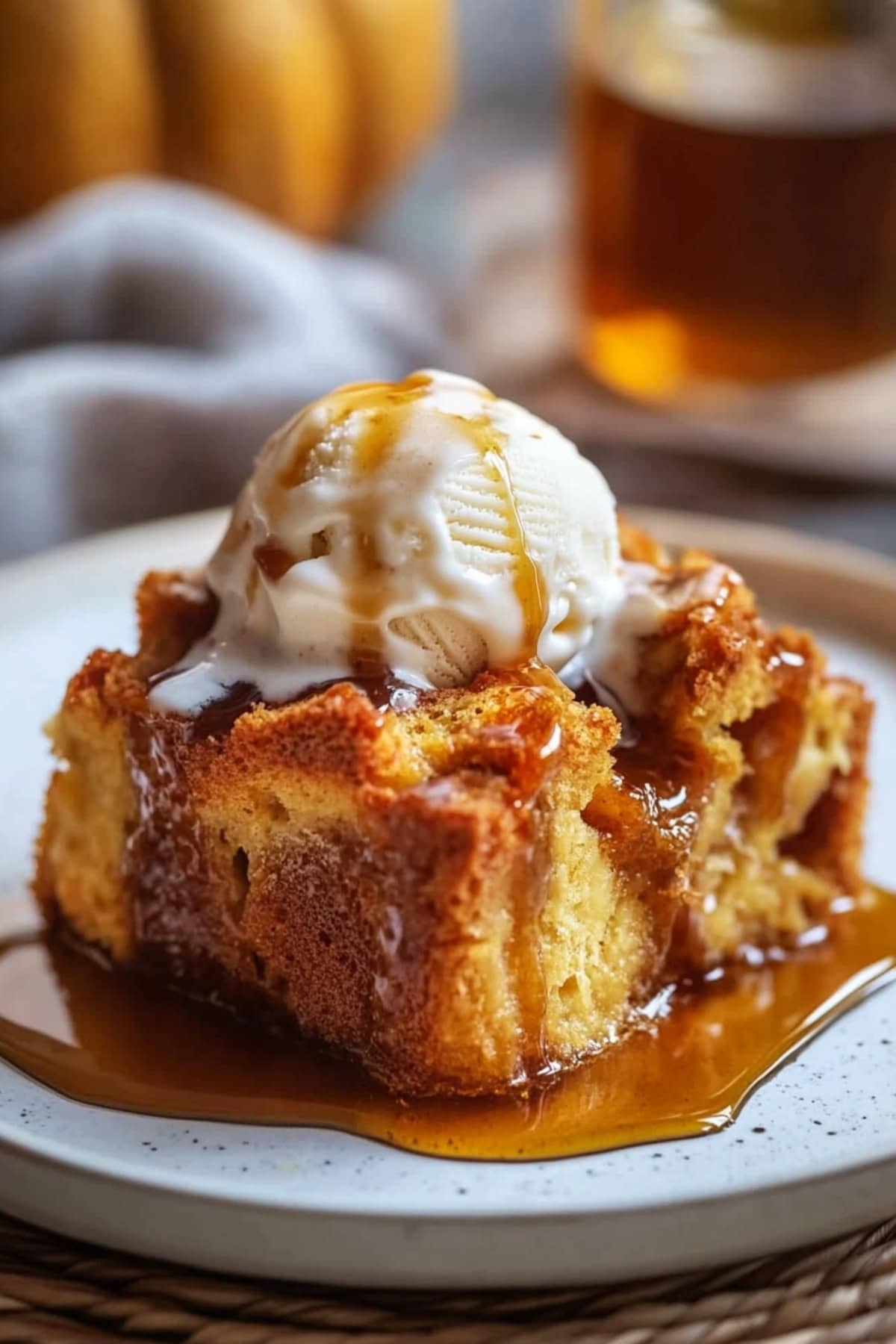 Pumpkin bread pudding with vanilla ice cream on top and drizzled with caramel sauce.