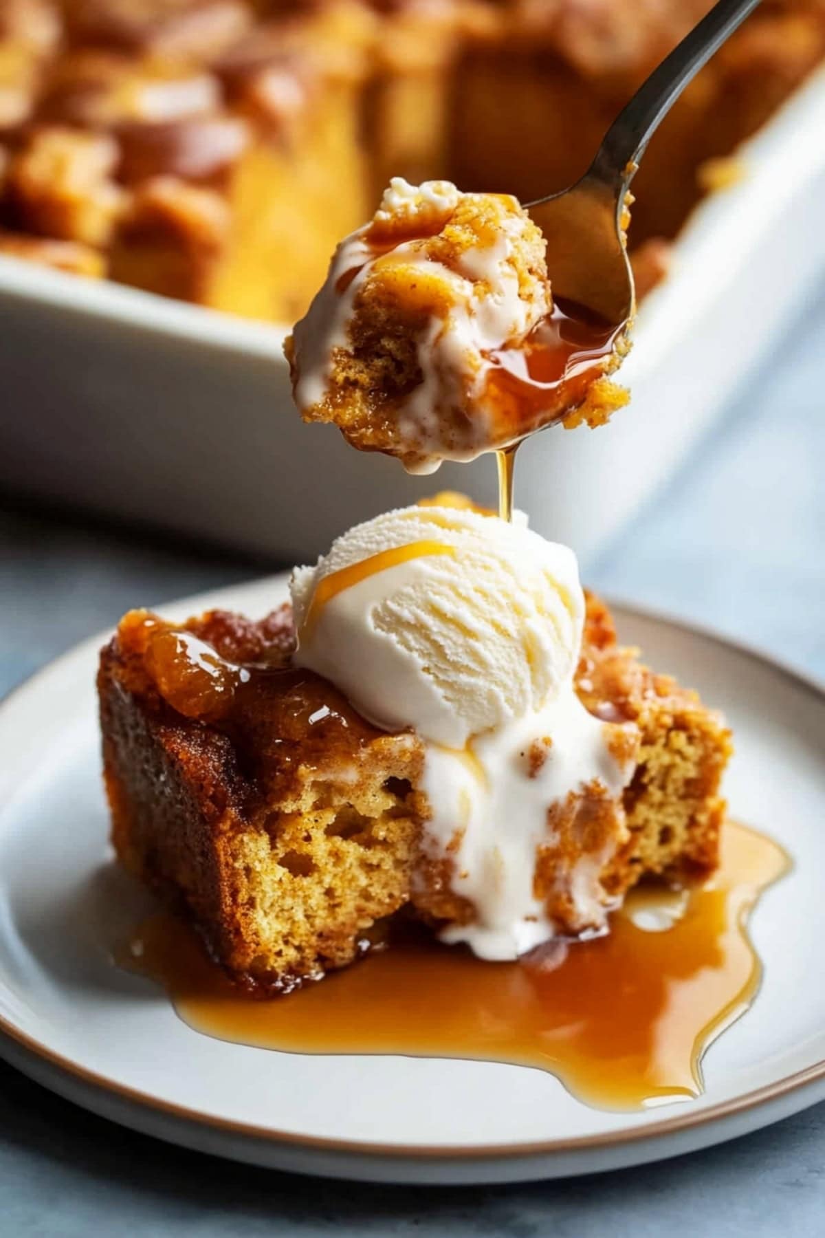 Spoon scooping pumpkin bread pudding from a plate