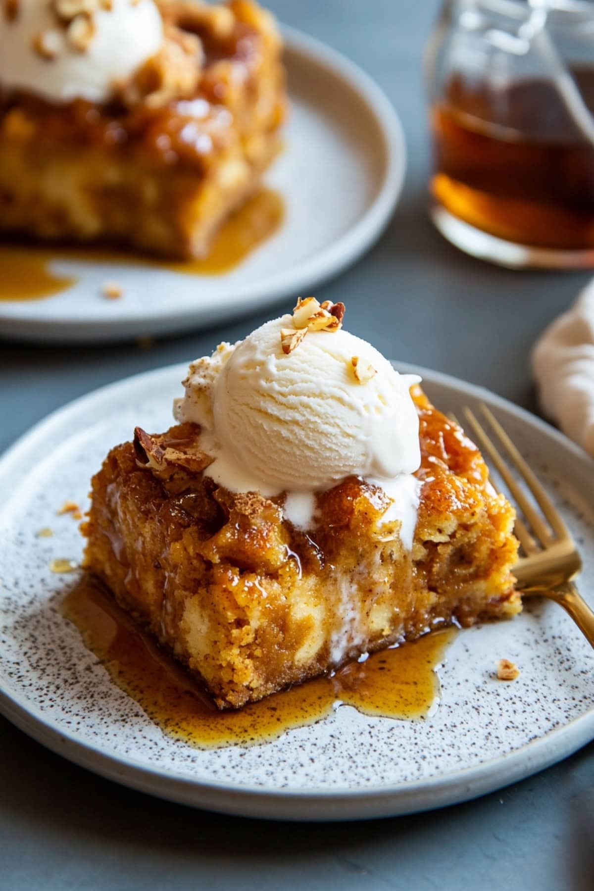 Portion of pumpkin bread pudding with a scoop of vanilla ice cream on top.