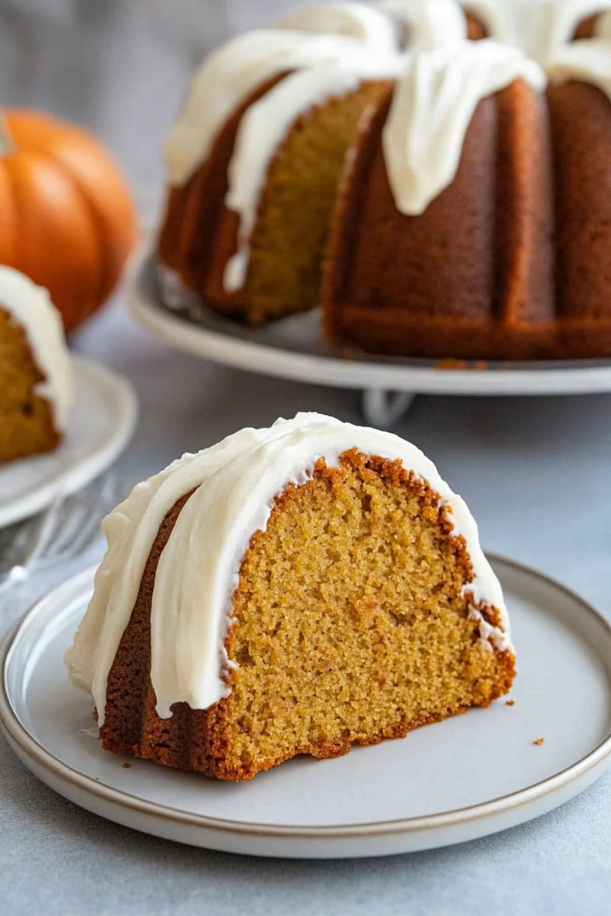 Slice of moist pumpkin cake covered in frosting