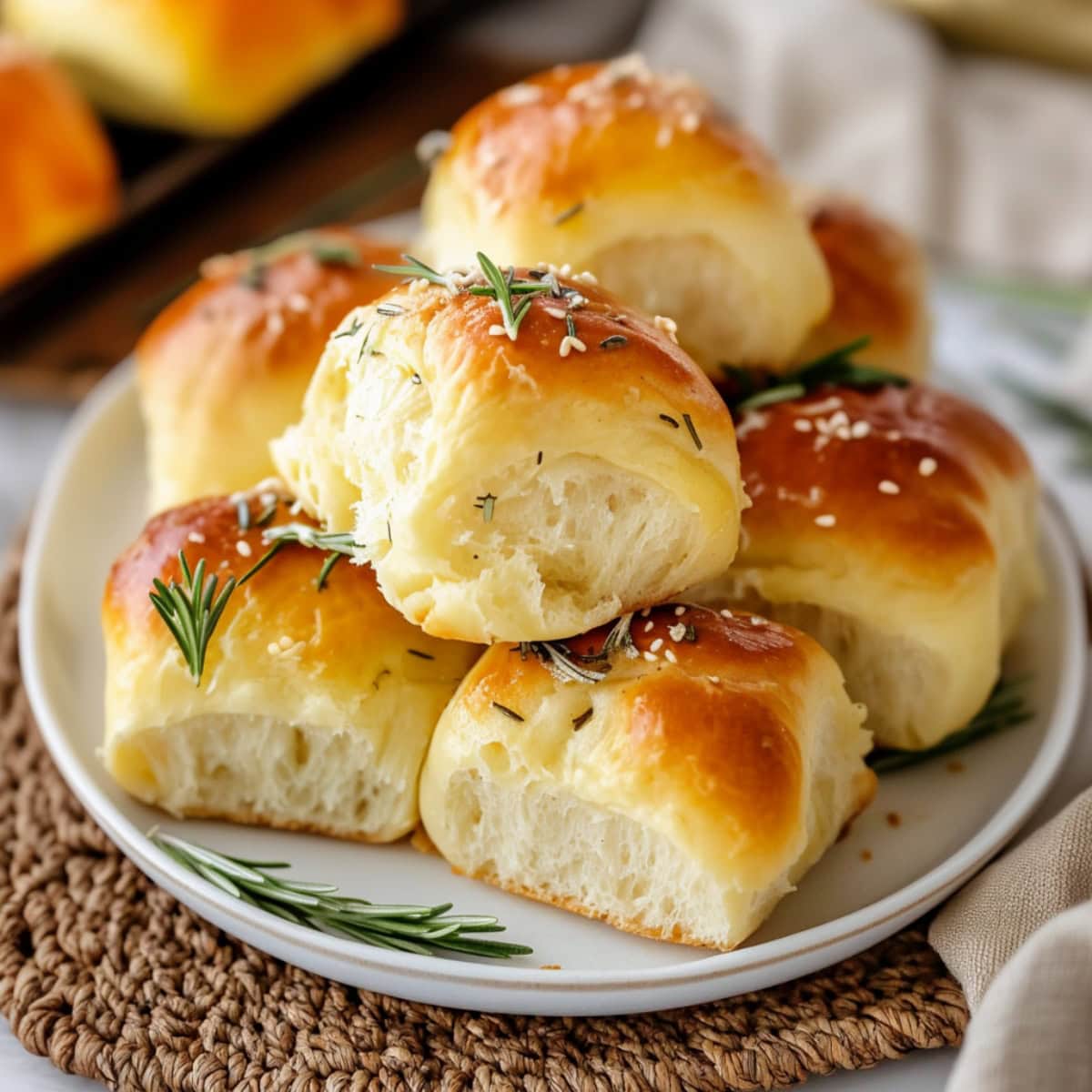 Golden-brown rosemary dinner rolls on a plate