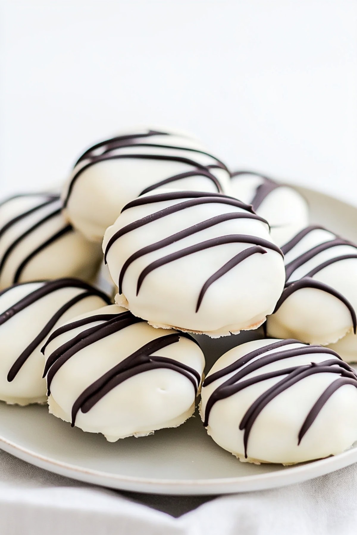 White chocolate-covered Oreos piled on a plate