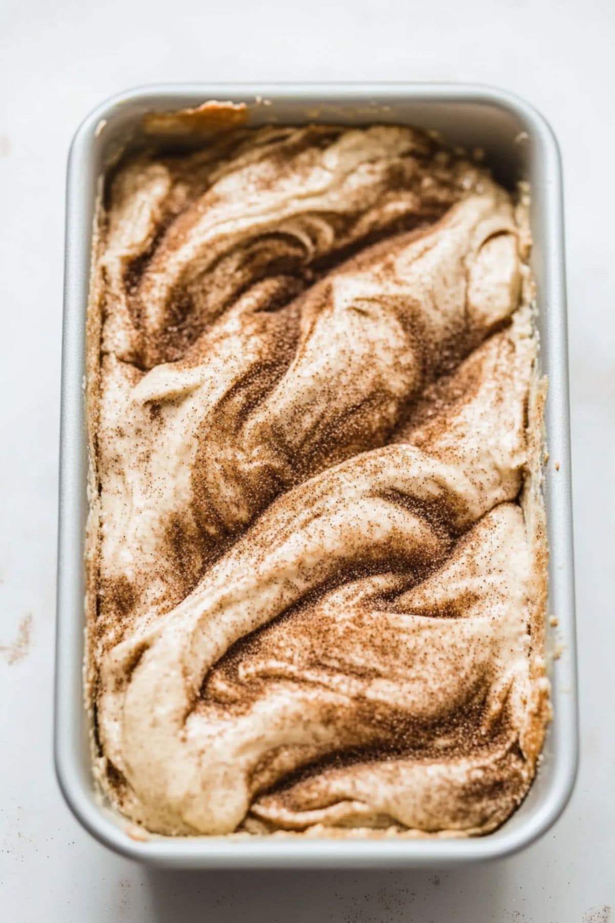 Cinnamon bread batter in a loaf pan.