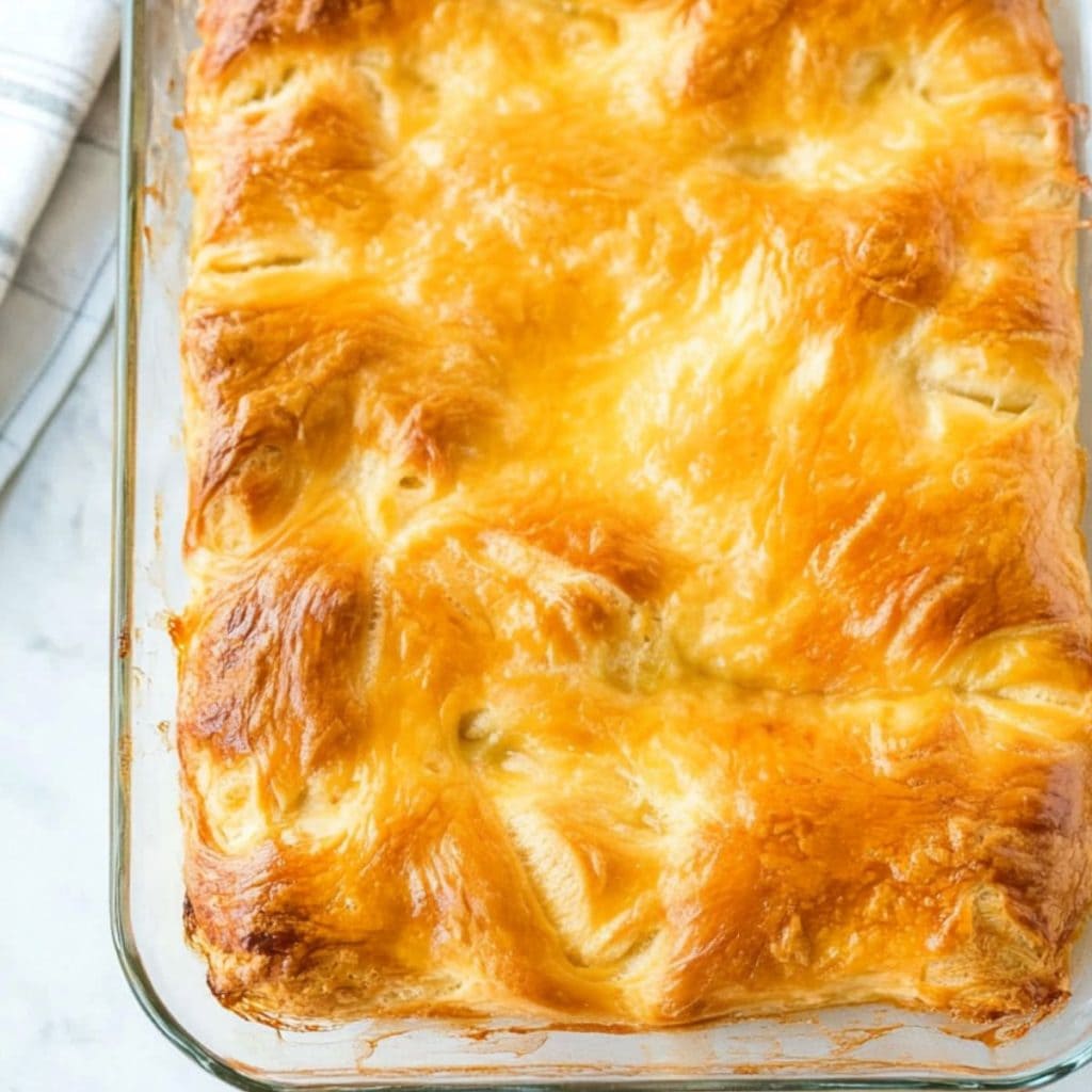 Baked whole crescent roll dough in a glass baking dish.