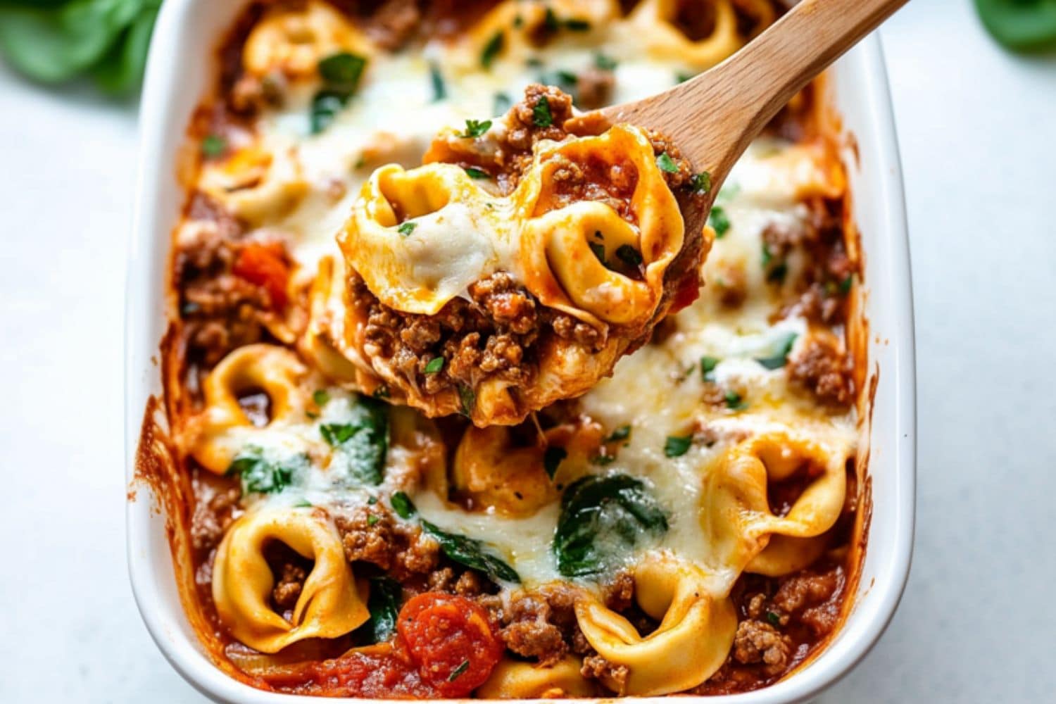 Baked tortellini in a white baking dish.