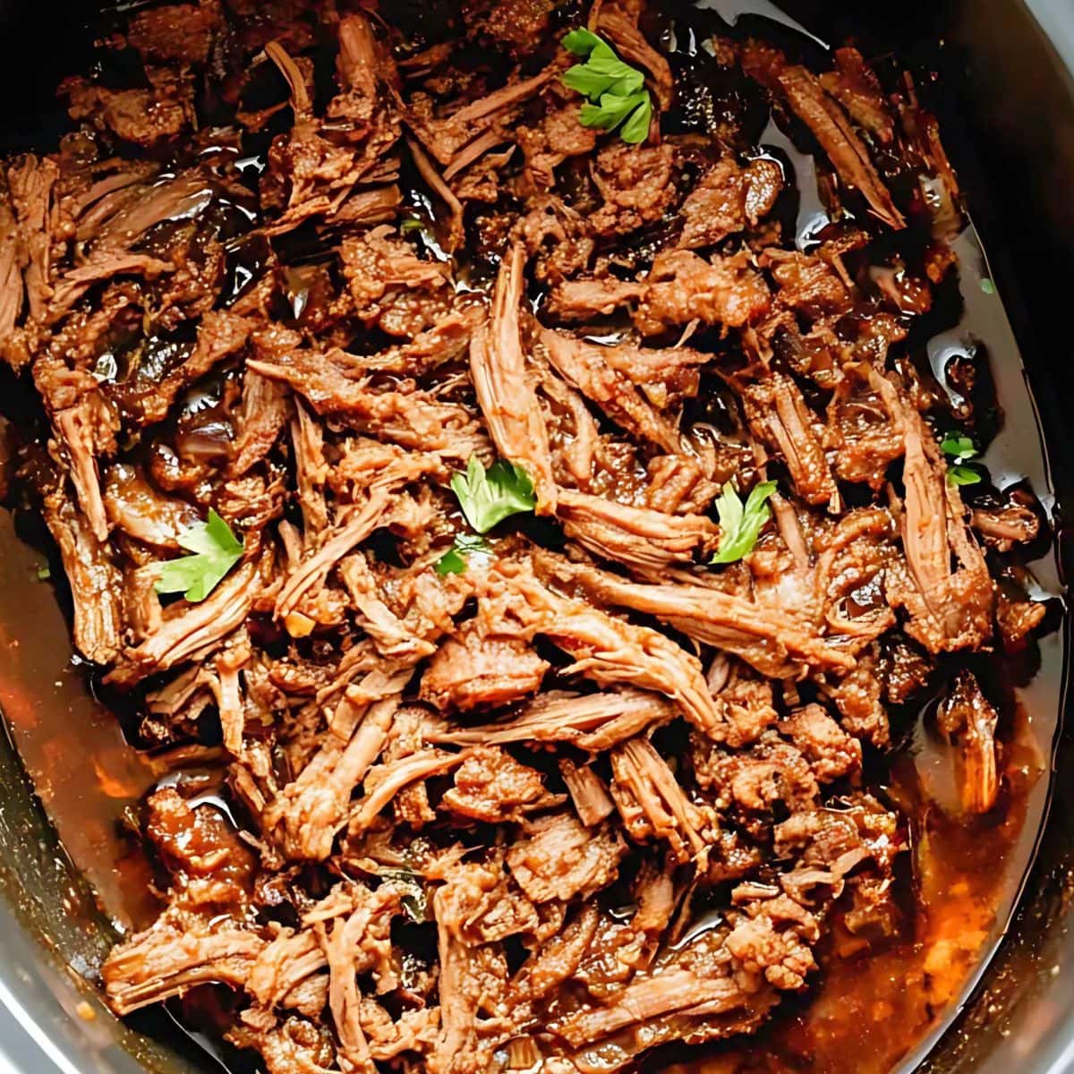 Shredded chuck roast cooked in a slow cooker.