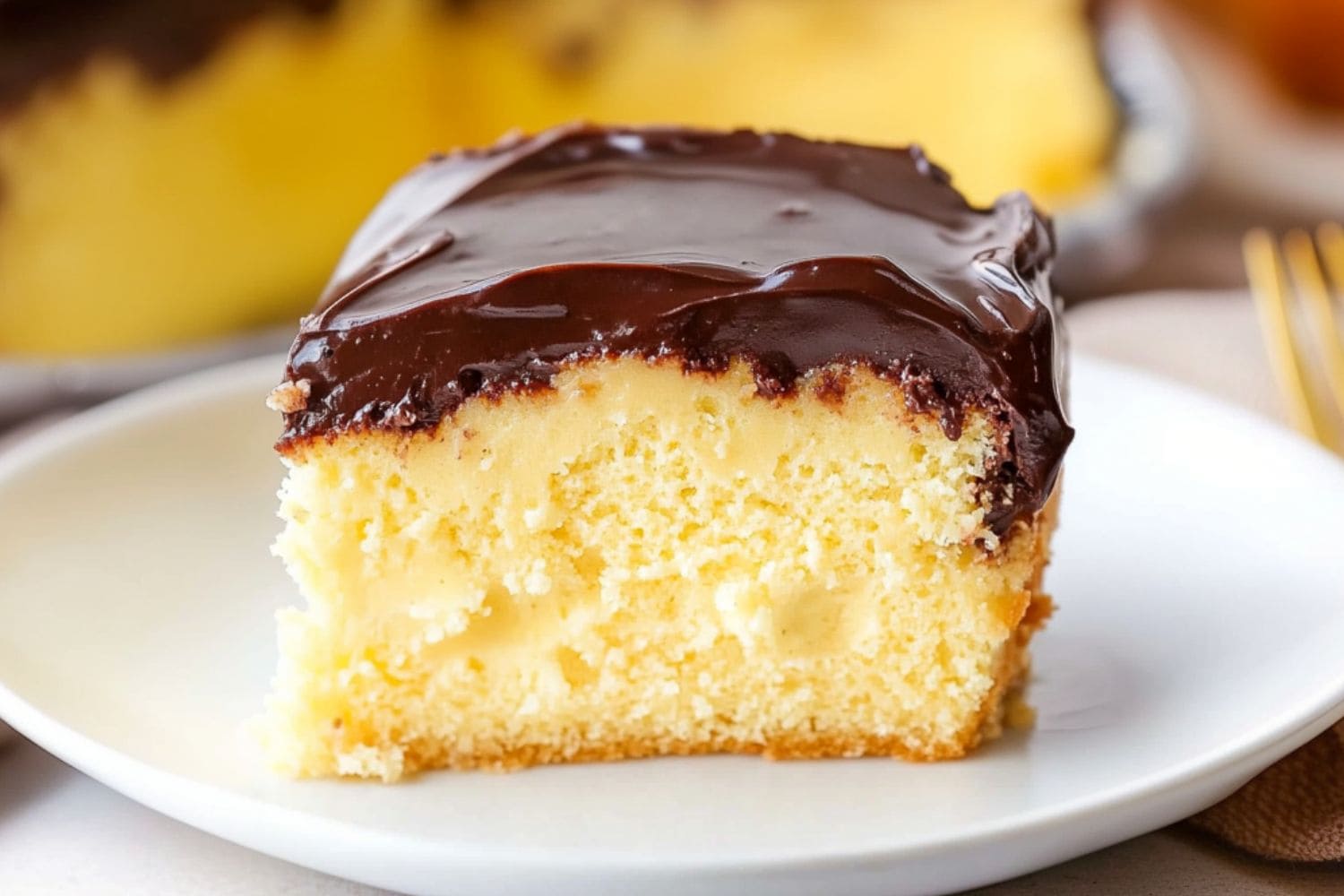 Boston cream pie poke cake slice served in a white plate.