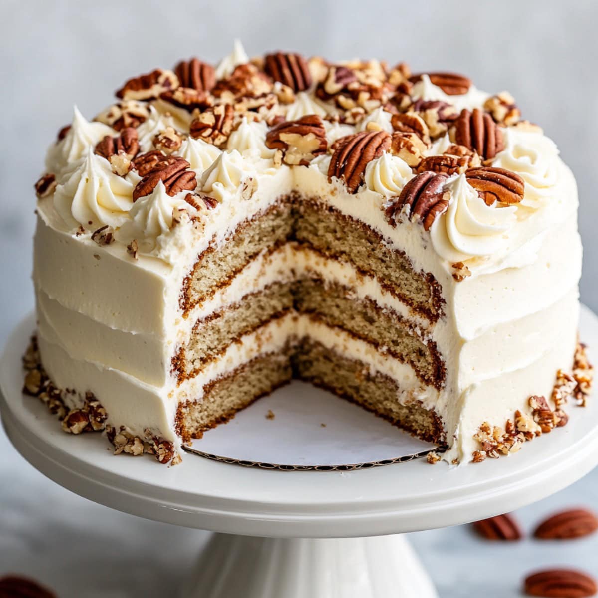 Butter Pecan Cake on a cake stand with a Slice Removed