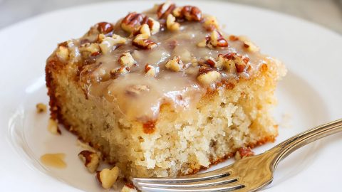 Moist butter pecan praline poke cake topped with nuts.