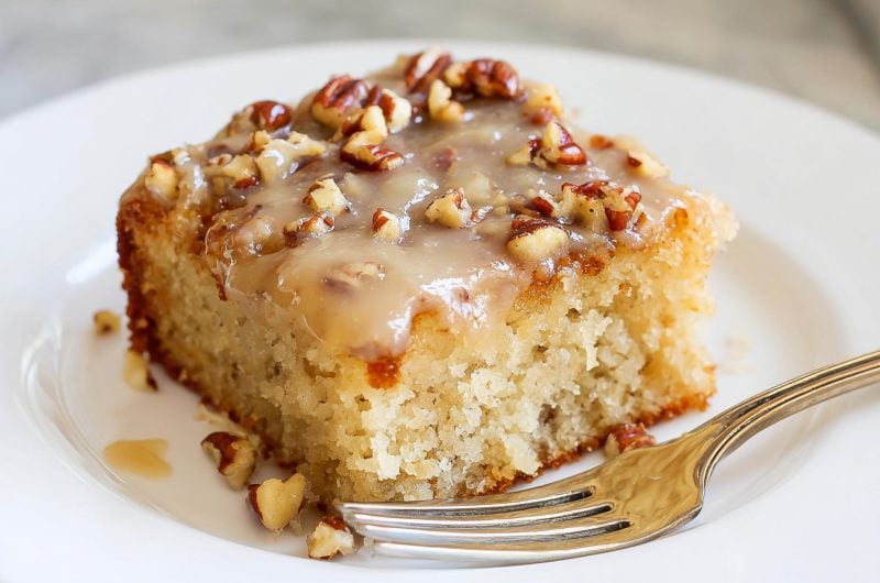 Moist butter pecan praline poke cake topped with nuts.