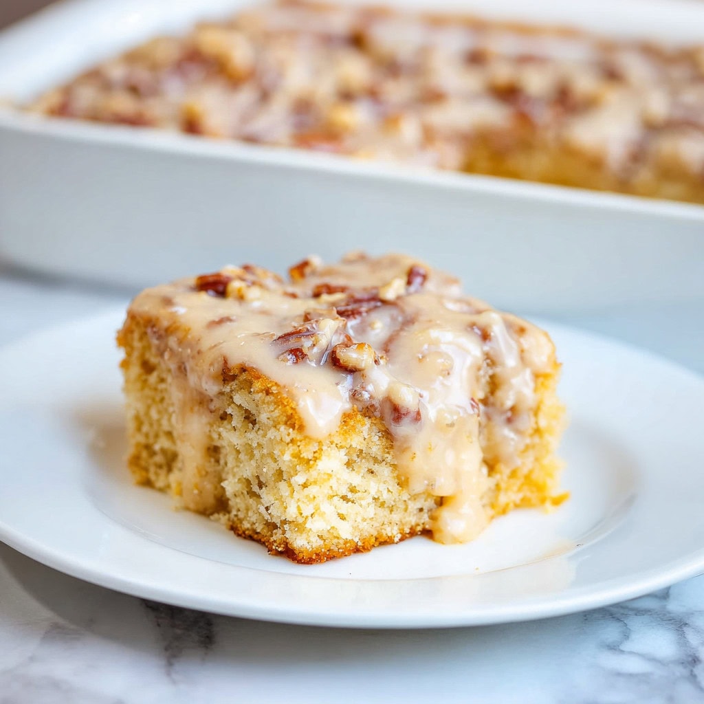 A slice of butter praline pecan poke cake in a plate.
