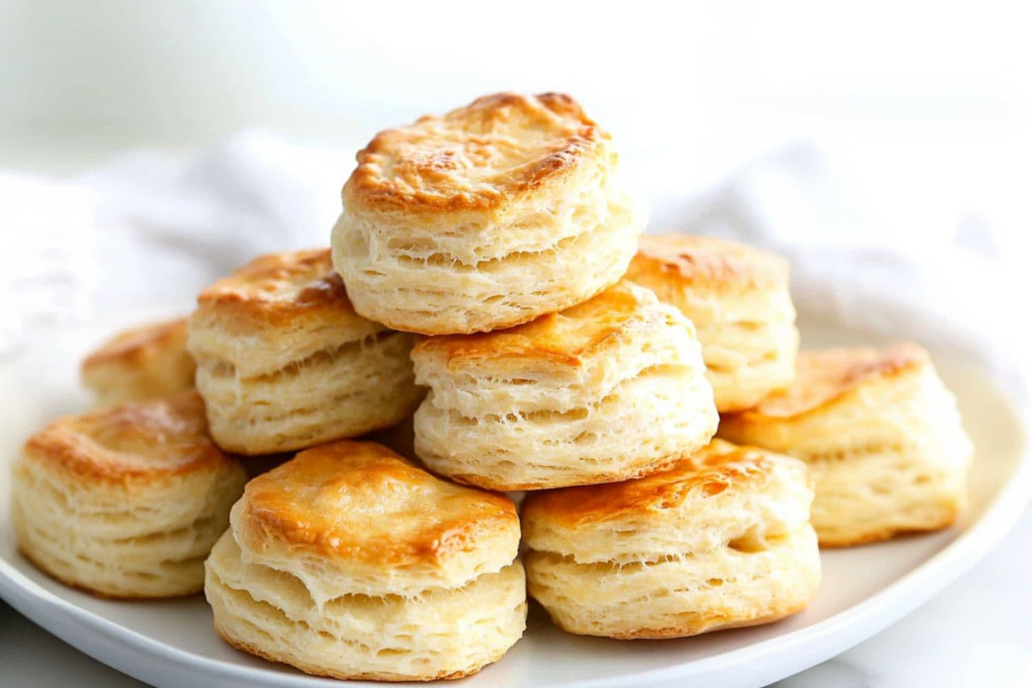 Bunch of buttermilk biscuits served in a white plate.