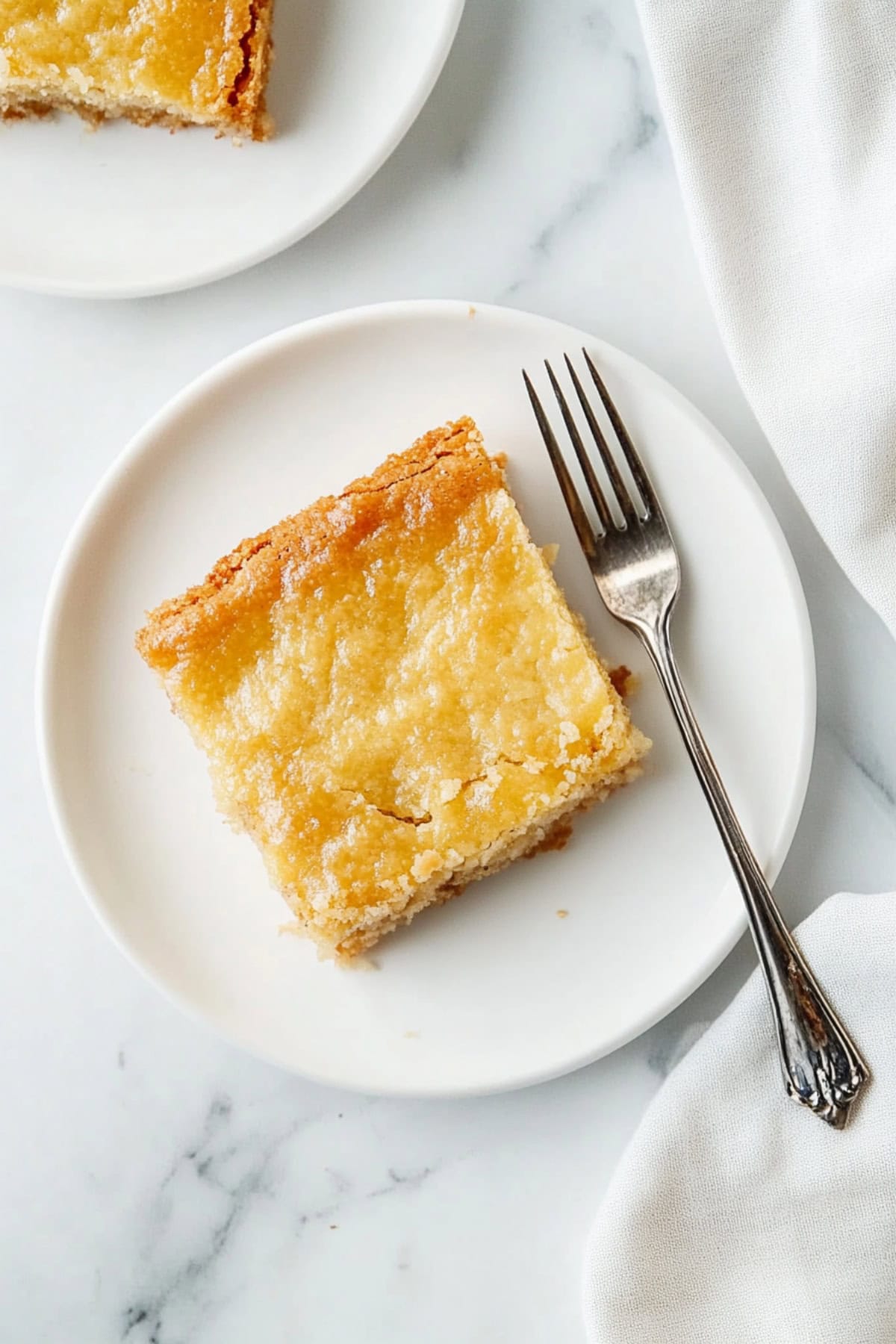 A piece of chess square in a plate with fork on the side.