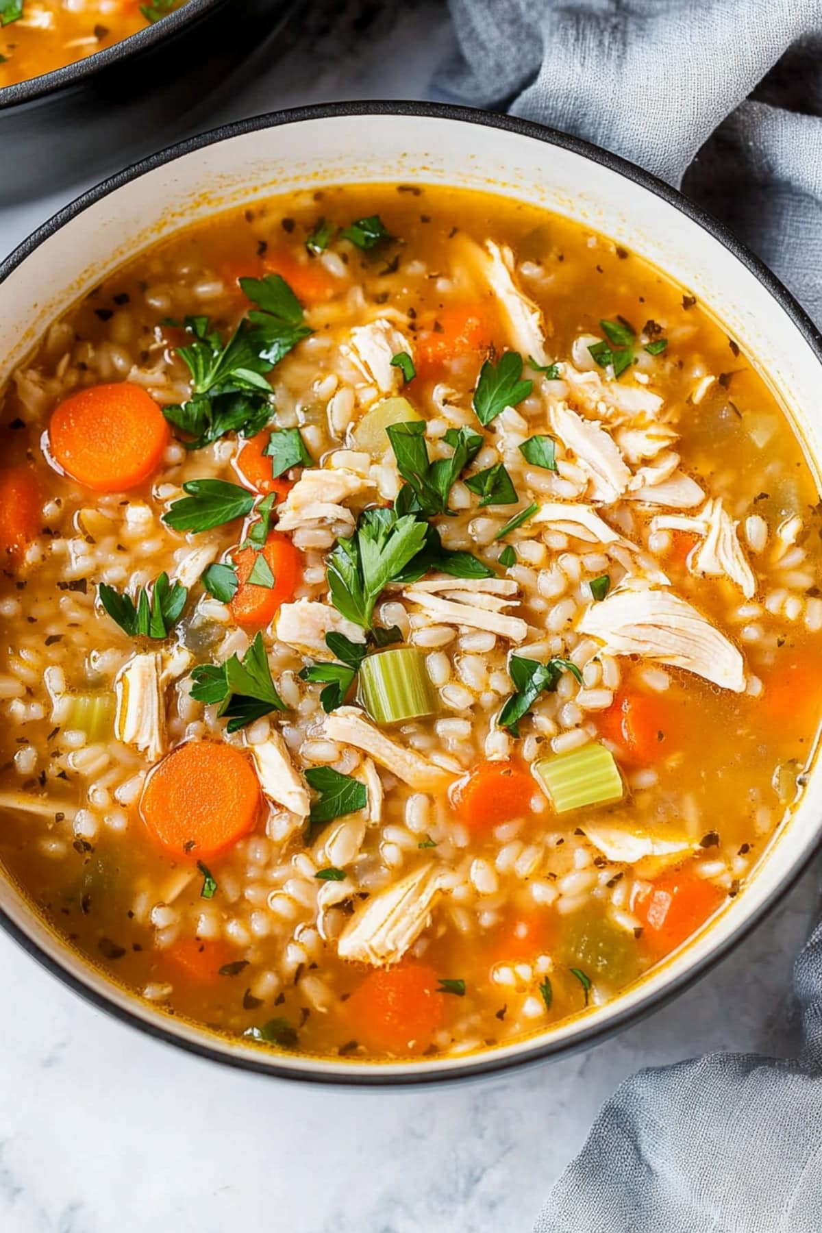 Close-up of a hearty chicken barley soup with celery, carrots and parsley.