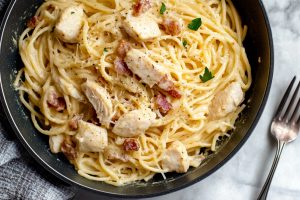 Homemade creamy and savory chicken carbonara with bacon bits, parmesan and herbs.