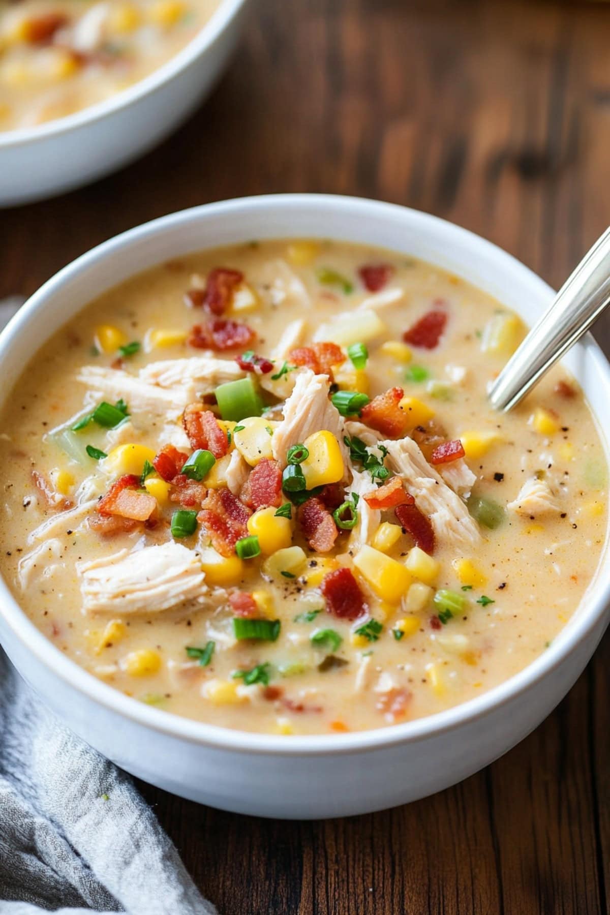 Creamy chicken and corn chowder with bacon, celery and onions in a bowl.