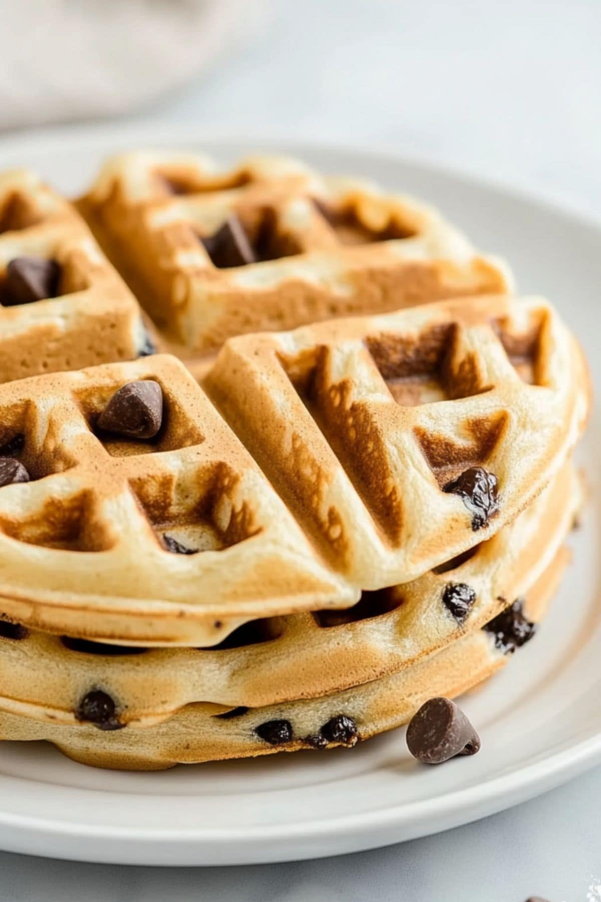 Waffles with mini chocolate chips served in a white plate.